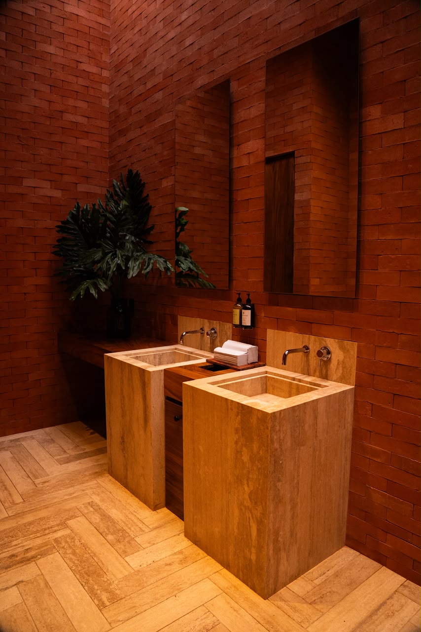 Detalle arquitectónico de los sanitarios de Salón Jardín en travertino y ladrillo artesanal